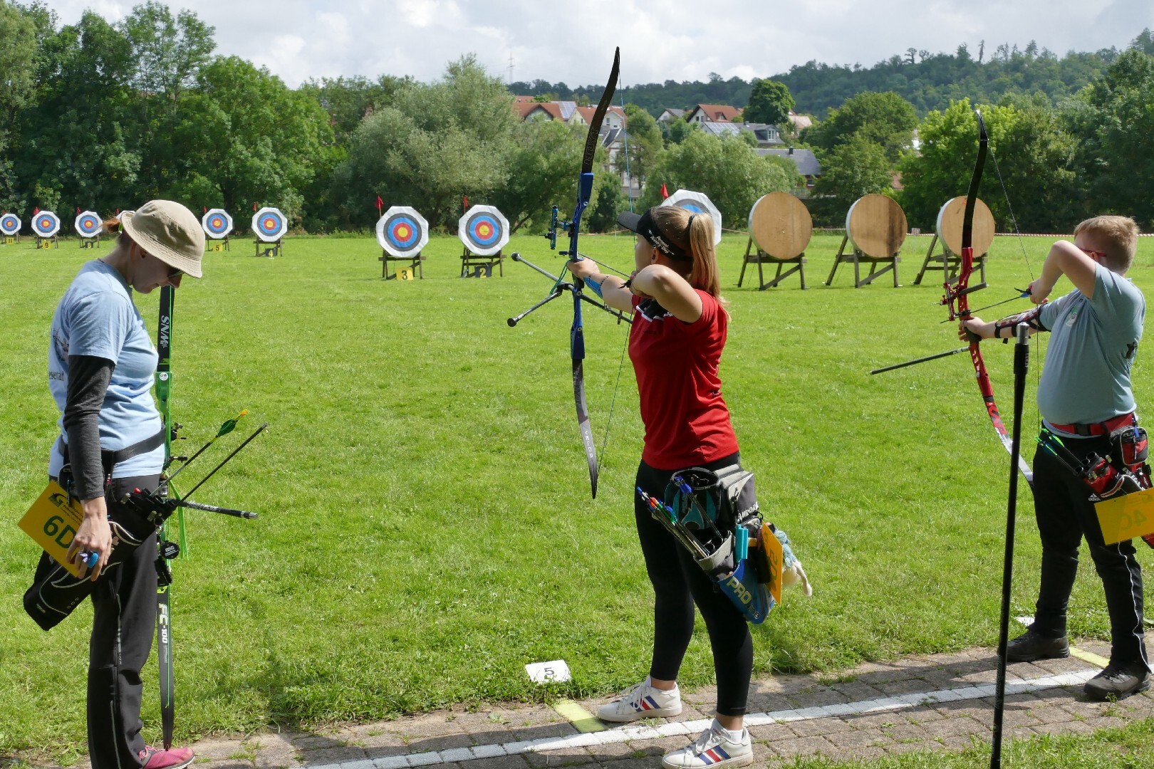 Three archers shooting at an outdoor competition