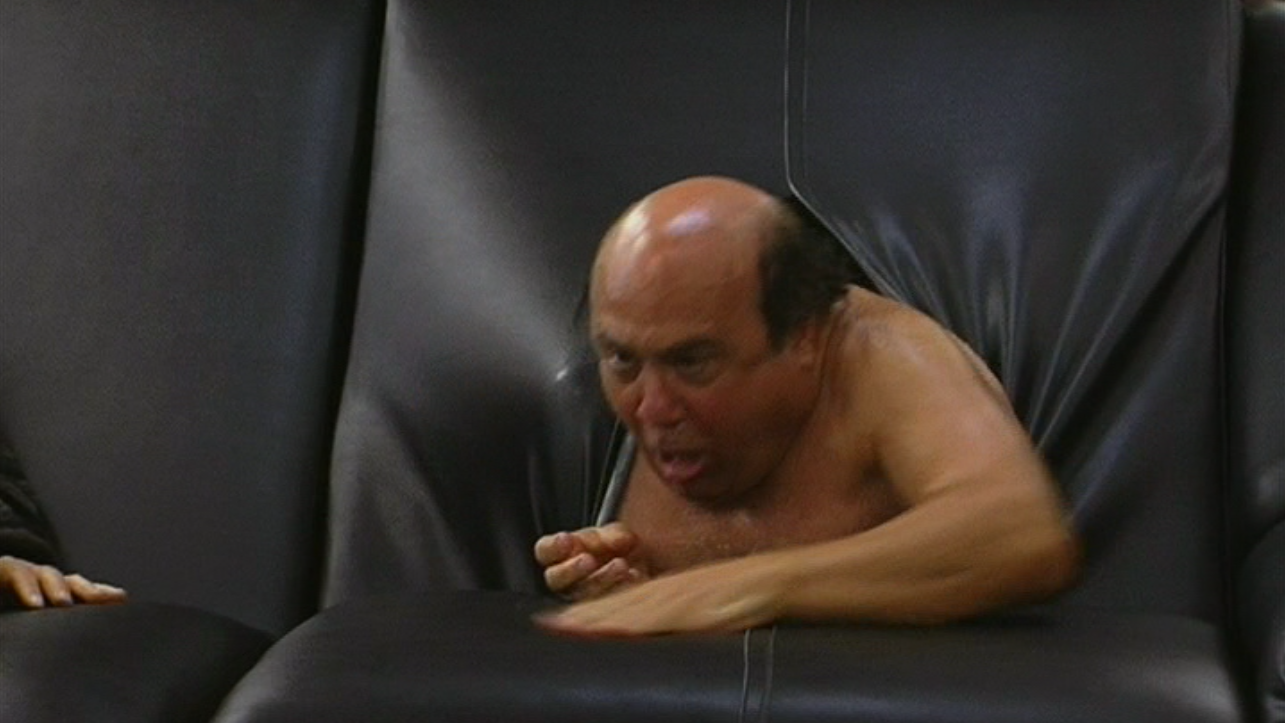 Danny Devito crawling out through a black sofa