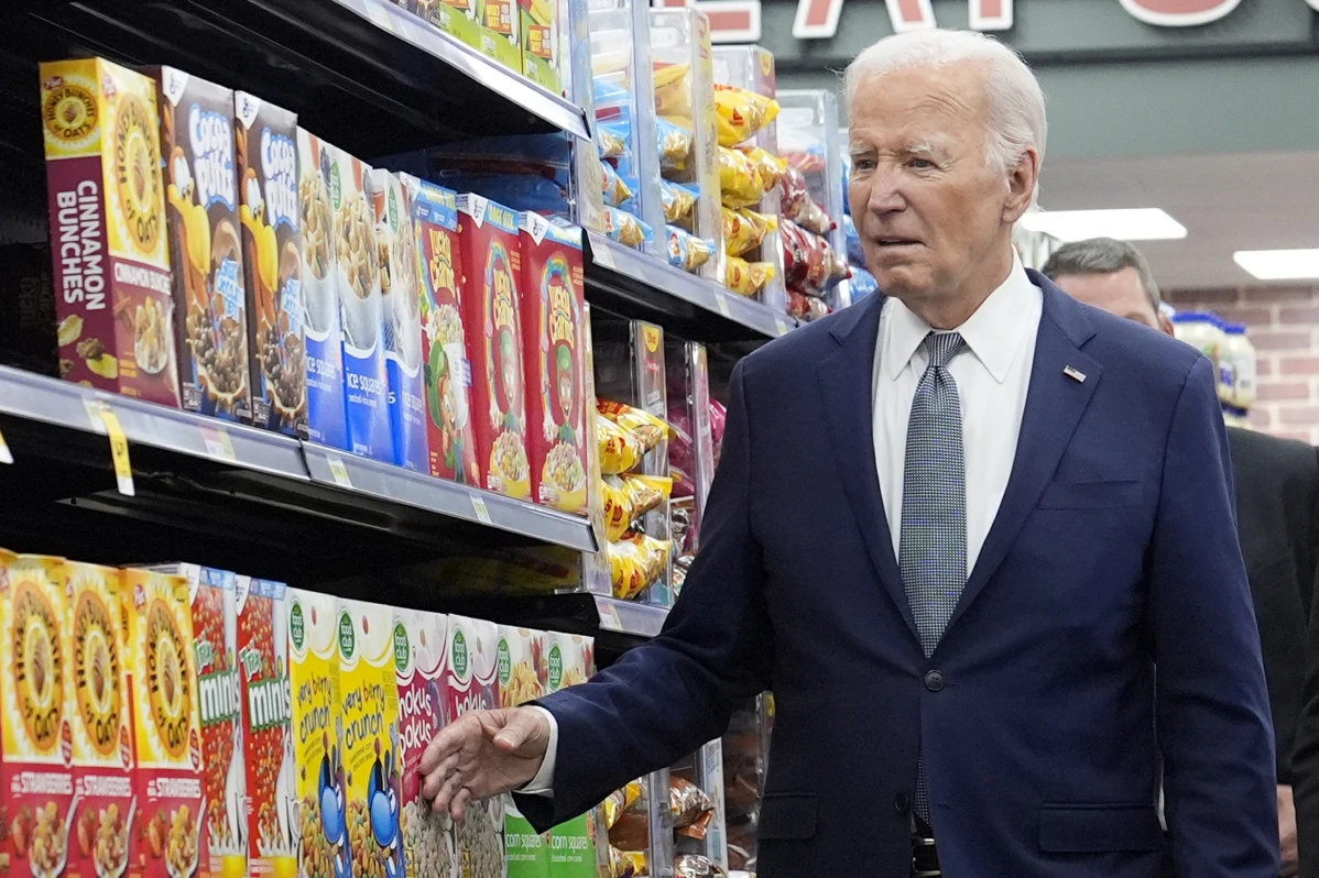 Biden walking in supermarket caressing boxes of cereal 